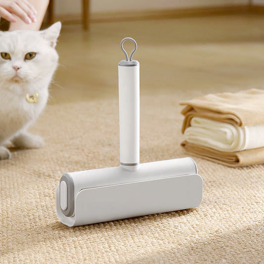 Pet hair removal roller on a carpet with a white cat in the background
